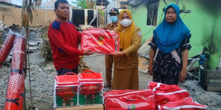 Dinas Sosial Kabupaten Pohuwato, saat memberikan bantuan kepada korban kebakaran di Desa Buntulia Barat, Kecamatan Duhiadaa, Kabupaten Pohuwato, Selasa (07/12/2021). (Foto istimewa).