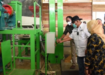 Gubernur Rusli Habibie saat mengecek beras hasil gilingan padi modern atau Rice Milling Unit (RMU), yang baru saja diresmikan dan beroperasi di Desa Pulahenti, Kecamatan Sumalata, Kabupaten Gorontalo Utara,  Sabtu (4/12/2021). (Foto: Salman)