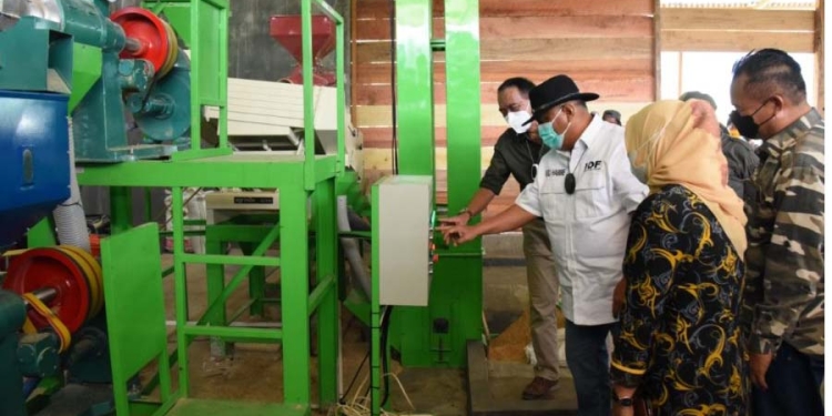 Gubernur Rusli Habibie saat mengecek beras hasil gilingan padi modern atau Rice Milling Unit (RMU), yang baru saja diresmikan dan beroperasi di Desa Pulahenti, Kecamatan Sumalata, Kabupaten Gorontalo Utara, Sabtu (4/12/2021). (Foto: Salman)