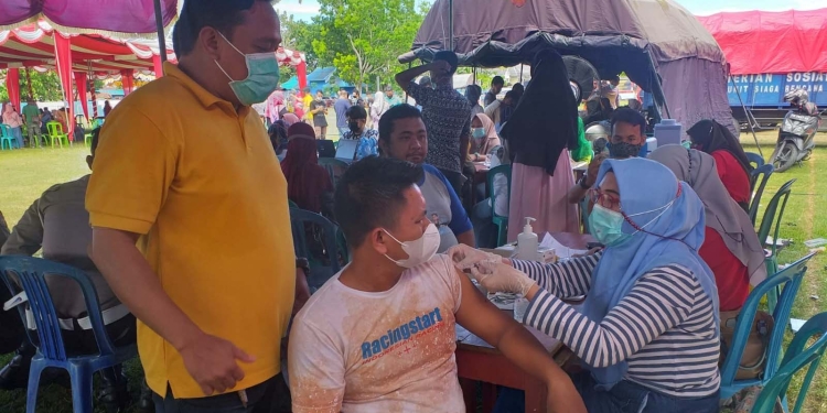 Masyarakat Bone Bolango saat mengikuti pelaksanaan vaksinasi di Lapangan Likada Kabila, Minggu (18/12/2021). (Foto: Indra/Gopos)