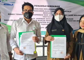 Penandatanganan PKS antara Kepala BPJS Ketenagakerjaan Cabang Gorontalo Hendra Elvian dengan Kepala Dinas Tenaga Kerja, Koperasi, dan UMKM Kabupaten Bone Bolango Roswaty Agus terkait kepesertaan perlindungan Jamsostek bagi 20.000 pekerja rentan tahun 2022, di Restaurant Angelato, Kota Gorontalo, Senin (24/1/2022). (Foto Istimewa)