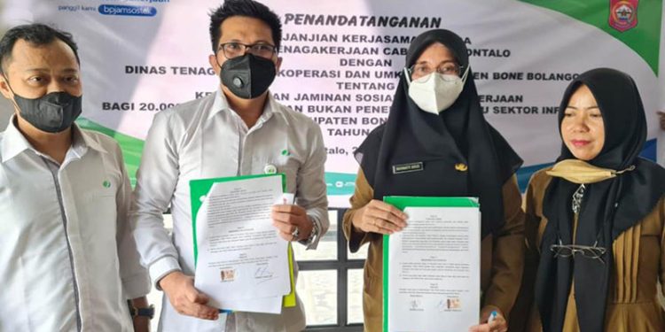 Penandatanganan PKS antara Kepala BPJS Ketenagakerjaan Cabang Gorontalo Hendra Elvian dengan Kepala Dinas Tenaga Kerja, Koperasi, dan UMKM Kabupaten Bone Bolango Roswaty Agus terkait kepesertaan perlindungan Jamsostek bagi 20.000 pekerja rentan tahun 2022, di Restaurant Angelato, Kota Gorontalo, Senin (24/1/2022). (Foto Istimewa)