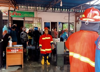 Petugas pemadam kebakaran melakukan pemadaman kebakaran yang melanda toko pakaian di Jl Sudirman atau depan Kampus UNG, Kota Gorontalo. (sari/gopos)