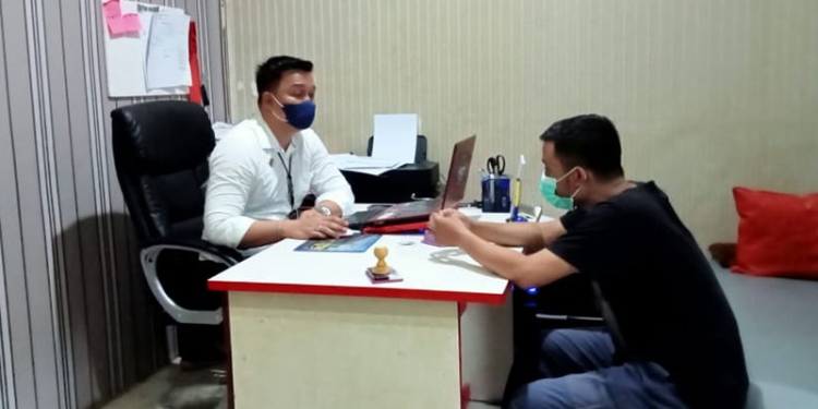 Tersangka JK (kaos hitam) saat menjalani pemeriksaan di Sat Reskrim Polres Gorontalo Kota. (sari/gopos)