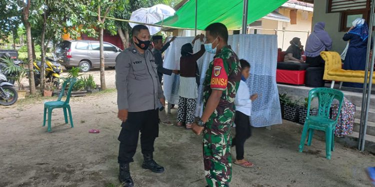 Personel Polsek Batudaa dan Koramil Tabongo mengawal di rumah korban di Dusun Balangga Selatan, Desa Payunga, Kecamatan Batudaa