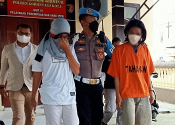 Dua tersangka penikaman di Kelurahan Padebuolo yang menewaskan Ilham Kamaru saat digiring petugas Polres Gorontalo Kota, Senin (3/1/2022). (sari/gopos)