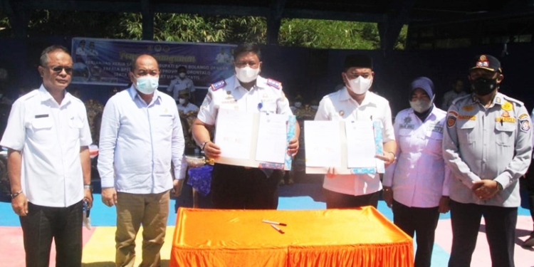 Ketua DPRD Kabupaten Bone Bolango, Halid Tangahu (Kedua dari kiri) saat menghadiri kegiatan launching alat uji statis kendaraan bermotor pertama di Provinsi Gorontalo di Bone Bolango bersama Bupati Bone Bolango, Hamim Pou. (Ketiga dari kanan) sekaligus melakukan penandatanganan perjanjian kerjasama dengan BPTD Wilayah XXI Provinsi Gorontalo di halaman DLHPP Bone Bolango, Rabu (12/1/2022). (Foto: Istimewa)