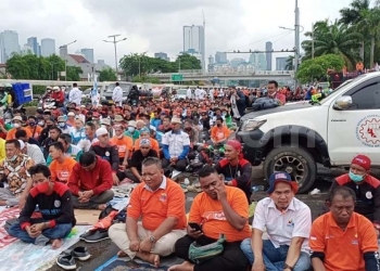 Ribuan buruh serta sejumlah elemen lainnya menggelar salat Jumat di sela-sela aksi unjuk rasa menolak UU Omnibus Law Cipta Kerja di depan Gedung DPR RI, Senayan, Jakarta, Jumat (14/1/2022). (Suara.com/Bagaskara)