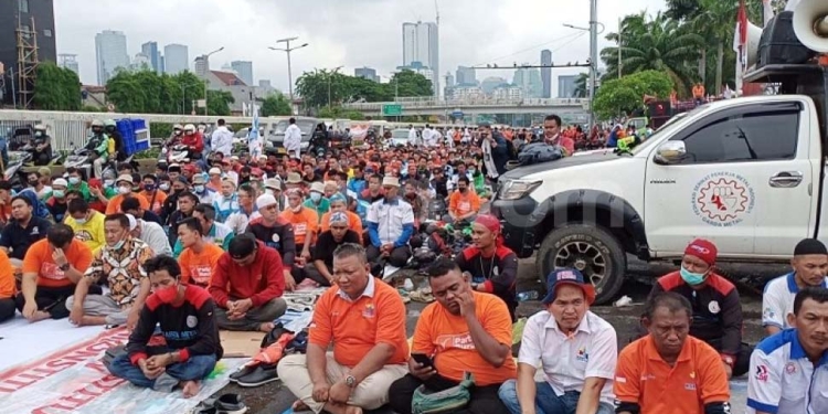 Ribuan buruh serta sejumlah elemen lainnya menggelar salat Jumat di sela-sela aksi unjuk rasa menolak UU Omnibus Law Cipta Kerja di depan Gedung DPR RI, Senayan, Jakarta, Jumat (14/1/2022). (Suara.com/Bagaskara)