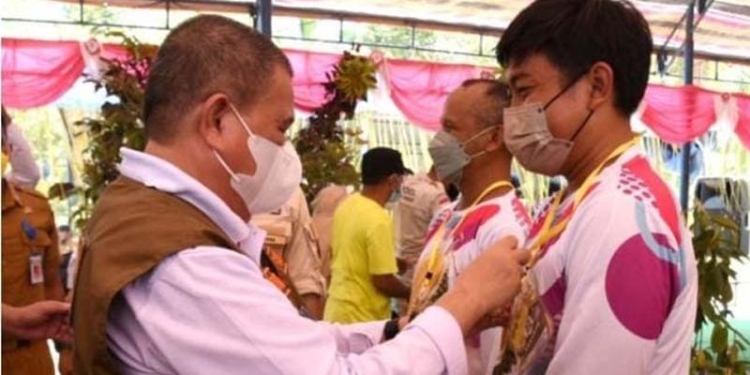 Wagub Gorontalo H. Idris Rahim (kiri) menyematkan tanda peserta bimtek pembudidayaan durian di Desa Ogorandu, Kecamatan Bolano Lambunu, Kabupaten Parigi Moutong, Senin (24/1/2022). Bimtek diikuti oleh 65 petani milenial Gorontalo. (Foto: Haris)