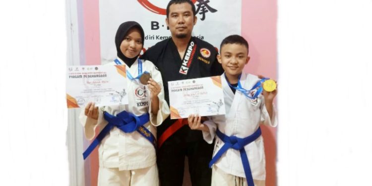 Ketua Umum (NFKI) Provinsi Gorontalo, sekaligus Ketua Komisi Teknik, Pelatihan dan Perwasitan Beladiri Kempo Indonesia Gorontalo, Muhammad Yusuf (Tengah) berfoto bersama peraih medali emas, Abdul Wafi Al Hafiz (kanan) dan peraih medali perunggu, Nur Azizah Musa (Kiri). (Foto: Istimewa)