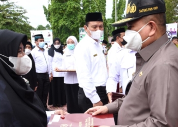 Wagub Gorontalo, Idris Rahim (kanan), saat menyerahkan piagam penghargaan Satyalancana Karya Satya 30 tahun kepada PNS Kementerian Agama pada upacara peringatan HAB ke-76 Kementerian Agama di Alun-Alun Tilamuta, Kabupaten Boalemo, Senin (3/1/2022). (Foto : Haris)