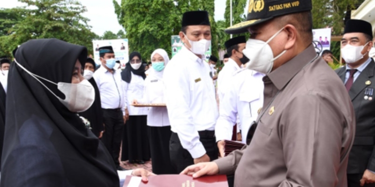 Wagub Gorontalo, Idris Rahim (kanan), saat menyerahkan piagam penghargaan Satyalancana Karya Satya 30 tahun kepada PNS Kementerian Agama pada upacara peringatan HAB ke-76 Kementerian Agama di Alun-Alun Tilamuta, Kabupaten Boalemo, Senin (3/1/2022). (Foto : Haris)