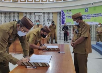 Sekretaris Daerah Provinsi Gorontalo Darda Daraba (kanan) menyaksikan penandatanganan perjanjian kinerja Asisten Pemerintahan dan Asisten Ekonomi dan Pembangun Setda Provinsi Gorontalo, di ruang Dulohupa Kantor Gubernur Gorontalo, Senin (31/1/2022). Sekda Darda berharap dokumen yang ditandatangani bukan hanya bersifat administratif, tetapi harus memilikii efek ke bawah dan ke samping dalam organisasi. (Foto: Nova)