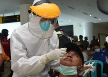 Salah satu petugas di bandar udara Jalaludin Gorontalo saat di PCR oleh petugas covid-19 di Bandara Jalaludin Gorontalo, Kamis (6/1/2022). PCR massal ini dilakukan untuk memastikan transmisi lokal penularan varian omicron di bandar udara. (Foto – Salman)