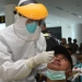 Salah satu petugas di bandar udara Jalaludin Gorontalo saat di PCR oleh petugas covid-19 di Bandara Jalaludin Gorontalo, Kamis (6/1/2022). PCR massal ini dilakukan untuk memastikan transmisi lokal penularan varian omicron di bandar udara. (Foto – Salman)