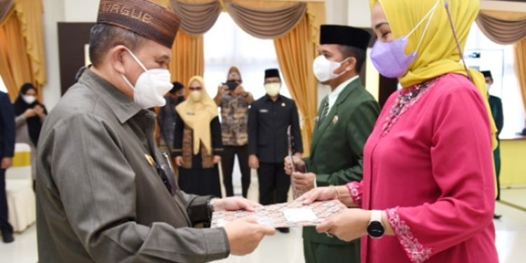 Wagub Gorontalo Idris Rahim (kiri) saatmenyerahkan SK Gubernur Gorontalo kepada pejabat yang dilantik di aula rumah jabatan Gubernur Gorontalo, Jumat (31/12/2021). (Foto : Haris)