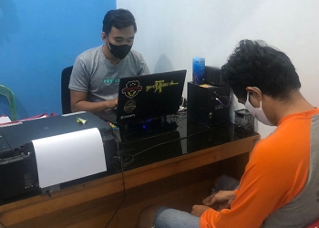 Petugas Polsek Kota Timur memeriksa AHA terduga pelaku pencurian handphone. (Humas Polres Gorontalo Kota)