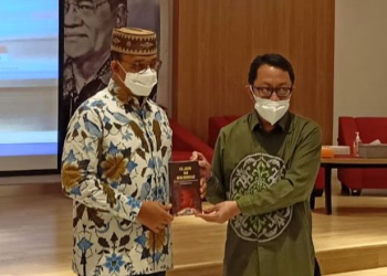 Anggota TP2GD Provinsi Gorontalo, dr. Muhammad Isman Jusuf, Sp.S (kanan), menyerahkan buku H.B Jassin kepada Gubernur DKI Jakarta Anies Baswedan pada Seminar Nasional pengusulan H.B Jassin sebagai Pahlawan Nasional di Kantor Perpustakaan Nasional, Jakarta, Selasa (22/2/2022). (Foto istimewa)