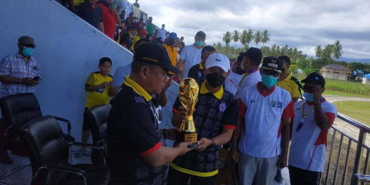 Bupati Pohuwato, Saipul Mbuinga (kedua dari kiri) saat menyerahkan piala bergilir kepada Ketua Askab PSSI Kabupaten Pohuwato, Nasir Giasi, sebagai tanda turnamen sepak bola Bupati Pohuwato Cup 2022 resmi dibuka, Sabtu (26/02/2022). (Yusuf/Gopos)