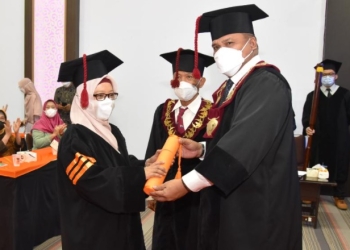 Eduart Wolok mengukuhkan Supartin S.Pd, M.Pd, dengan Gelar Doktor setelah berhasil melewati ujian terbuka disertasi promosi doktor dalam bidang pendidikan IPA, Selasa (8/2/2022), di Aula Pascasarjana UNG. (dok. UNG)