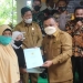 Wakil Bupati Gorontalo, Hendra S. Hemeto, menyerahkan sertifikat tanah kepada seorang penerima manfaat di Desa Molanihu, Kecamatan Bongomeme. (Foto: Istimewa)