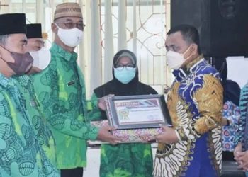 Wakil Bupati Gorontalo, Hendra S. Hemeto, saat menyerahkan penghargaan kepada kader Pembantu Pembina Keluarga Berencana Desa. di Aula Kementerian Agama Kabupaten Gorontalo, Selasa (11/01/2022). (Foto:  Istimewa).