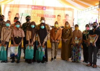 Gubernur Gorontalo Rusli Habibie didampingi Kakwarda Provinsi Gorontalo Idah Syahidah bersama siswa siswi Kwartir Cabang (Kwarcab) Pramuka yang mengikuti vaksinasi covid-19 di Kecamatan Marisa, Kabupaten Pohuwato, Selasa (8/2/2022). Foto – Salman