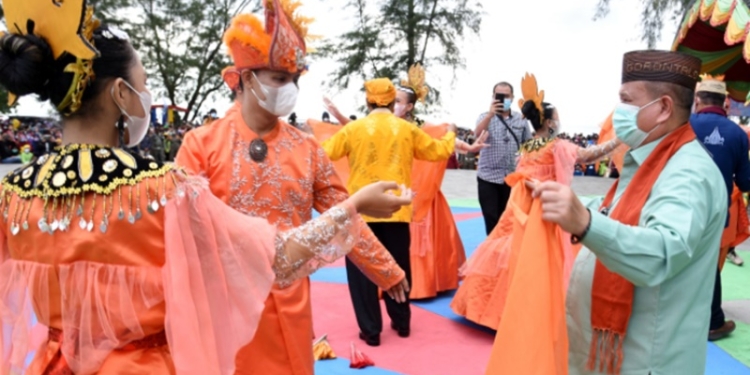 Wagub Gorontalo H. Idris Rahim (kanan) turut menari Tari Sa ronde pada pembukaan festival pariwisata “I Look Boalemo” di destinasi wisata Pantai Bolihutuo, Kabupaten Boalemo, Jumat (11/2/2022). (Foto : Haris)