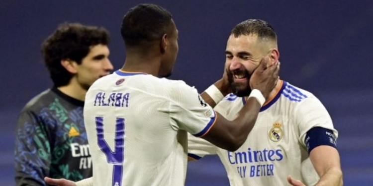 Bek Real Madrid asal Austria, David Alaba (kiri) dan pemain depan Real Madrid dari Prancis, Karim Benzema melakukan selebrasi di akhir pertandingan leg kedua babak 16 besar Liga Champions antara Real Madrid vs PSG di stadion Santiago Bernabeu, pada 10 Maret 2022 dini hari WIB. JAVIER SORIANO / AFP.