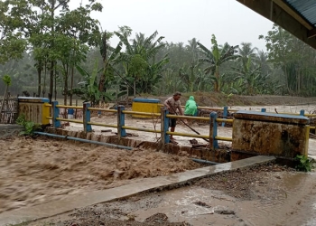 Sejumlah warga di Kecamatan Suwawa Selatan membersihkan material sampah yang hanyut terbawa arus air, Kamis (17/3/2022).