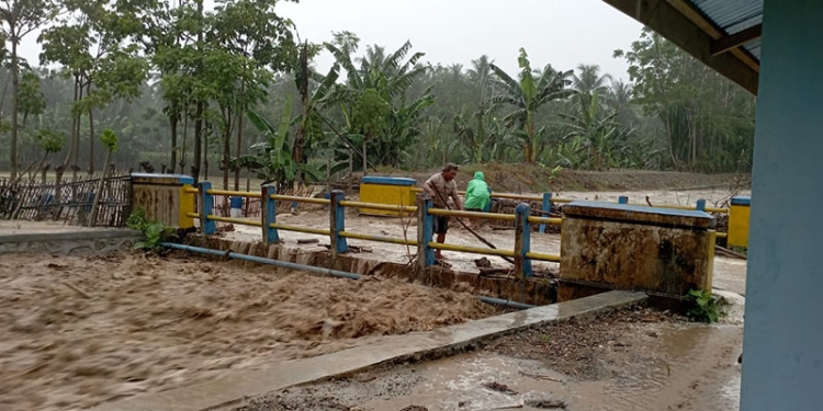 Sejumlah warga di Kecamatan Suwawa Selatan membersihkan material sampah yang hanyut terbawa arus air, Kamis (17/3/2022).