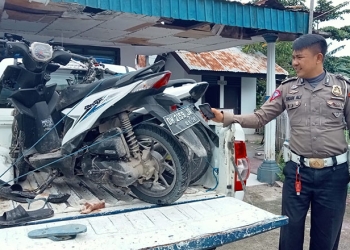 Petugas Satlantas Polres Gorontalo Kota mengamankan barang bukti dua sepeda motor dalam kecelakaan maut di Jl. Sultan Botutihe, Kelurahan Tamalate, Kota Timur, Kota Gorontalo, Kamis (24/3/2022). (Sari/gopos)
