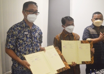 Bupati Gorontalo, Nelson Pomalingo (Tengah) ditemani Wakil Bupati Gorontalo, Hendra Hemeto (Kanan) saat menandatangani perjanjian kerja bersama General Manager Hotel Aston Gorontalo and Villas, Alain John Siwy (Kiri) di Hotel Aston Gorontalo, Jumat (48/3/2022). (Foto: Putra/Gopos)