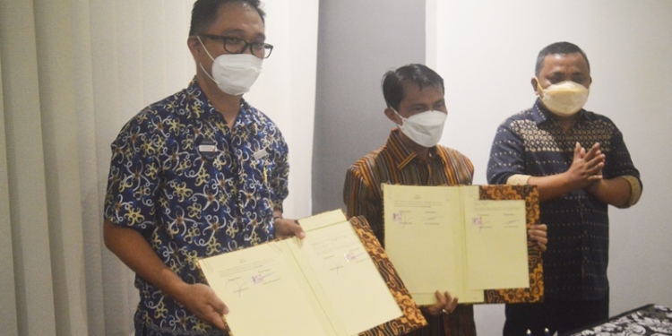 Bupati Gorontalo, Nelson Pomalingo (Tengah) ditemani Wakil Bupati Gorontalo, Hendra Hemeto (Kanan) saat menandatangani perjanjian kerja bersama General Manager Hotel Aston Gorontalo and Villas, Alain John Siwy (Kiri) di Hotel Aston Gorontalo, Jumat (48/3/2022). (Foto: Putra/Gopos)