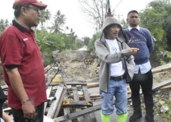 Bupati Gorontalo Nelson Pomalingo saat meninjau jembatan, jalan dan bendungan yang ambruk akibat diterjang banjir di Desa Molowahu, Kecamatan Tibawa, serta jembatan biyonga yang dihantam banjir di sejumlah Kelurahan dan Kecamatan Limboto, Ahad (20/3/2022). (foto: istimewa)