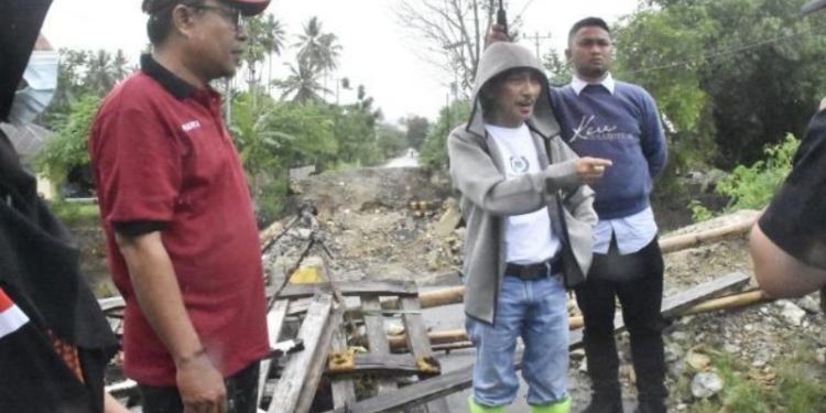 Bupati Gorontalo Nelson Pomalingo saat meninjau jembatan, jalan dan bendungan yang ambruk akibat diterjang banjir di Desa Molowahu, Kecamatan Tibawa, serta jembatan biyonga yang dihantam banjir di sejumlah Kelurahan dan Kecamatan Limboto, Ahad (20/3/2022). (foto: istimewa)