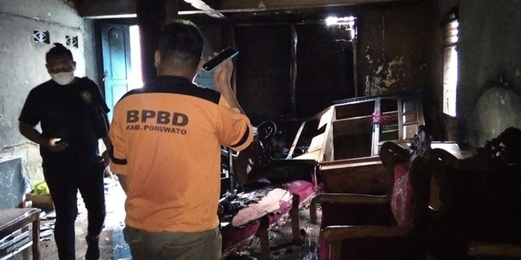 Petugas BPBD Pohuwato melakukan identifikasi dalam peristiwa kebakaran yang melanda rumah milik Meiske Arsyad, Selasa (8/3/2022). (Istimewa)