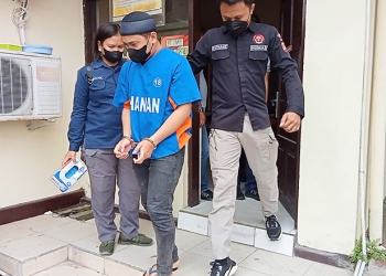MIS alias Panjul (25) digiring petugas Polres Gorontalo Kota. Panjul dijerat sangkaan pencurian 21 handphone (17 di antaranya Iphone) di sebuah toko handphone di Kota Gorontalo. (sari/gopos)