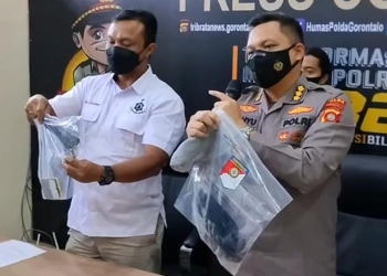 Kabid Humas Polda Gorontalo, Kombes Pol Wahyu Tri Cahyono (kanan) didampingi Direktur Reskrimum Polda Gorontalo, Kombes Pol Nur Santiko menunjukkan barang  bukti yang diamankan dalam perkara penembakan Direktur Tahti, AKBP Beni Mutahir. (putra/gopos)