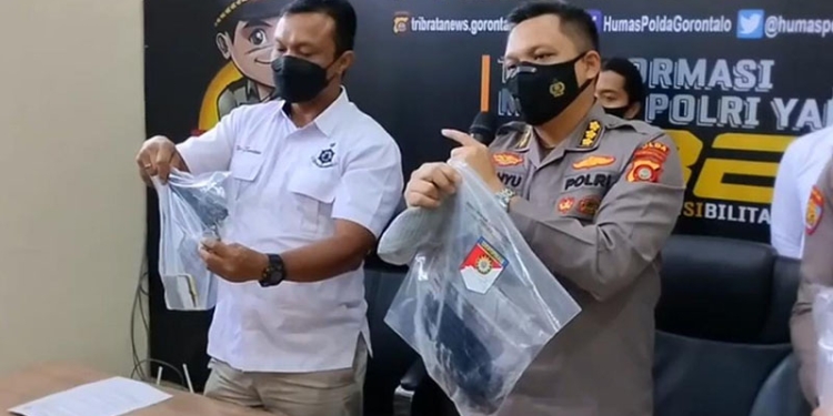 Kabid Humas Polda Gorontalo, Kombes Pol Wahyu Tri Cahyono (kanan) didampingi Direktur Reskrimum Polda Gorontalo, Kombes Pol Nur Santiko menunjukkan barang  bukti yang diamankan dalam perkara penembakan Direktur Tahti, AKBP Beni Mutahir. (putra/gopos)