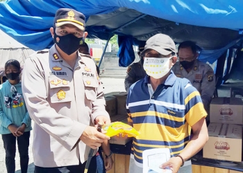Kapolres Gorontalo Kota, AKBP Suka Irawanto membagikan minyak goreng kepada masyarakat yang mengikuti vaksinasi Covid-19 dosis dua di Lapangan Taruna Remaja Kota Gorontalo, Sabtu (12/3/2022)