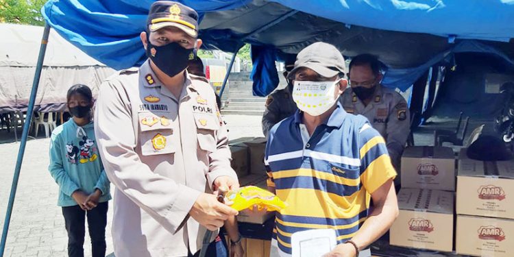 Kapolres Gorontalo Kota, AKBP Suka Irawanto membagikan minyak goreng kepada masyarakat yang mengikuti vaksinasi Covid-19 dosis dua di Lapangan Taruna Remaja Kota Gorontalo, Sabtu (12/3/2022)