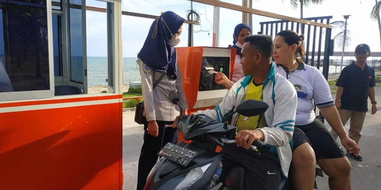 Dinas Perhubungan Pohuwato melakukan sosialisasi kepada pengendara maupun pengunjung mengenai pemberlakuan parkir elektronik di kawasan Pohon Cinta, Marisa, Pohuwato, Jumat (11/3/2022). (Yusuf/Gopos)