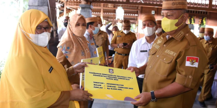 Gubernur Rusli Habibie (kanan), menyerahkan secara simbolis TPP kepada PNS Pemprov Gorontalo di aula Villa Kencana Bolihutuo, Kabupaten Boalemo, Senin (28/3/2022). (Foto: Salman)