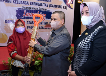 Wagub Gorontalo H. Idris Rahim (tengah) menyerahkan bantuan alat TTG kepada Kelompok UPPKA Beringin Kampung KB Tomulabutao pada penguatan kemitraan dan peluncuran program Dashat di Hotel Grand Q, Kota Gorontalo, Kamis (24/3/2022). (Foto: Haris)