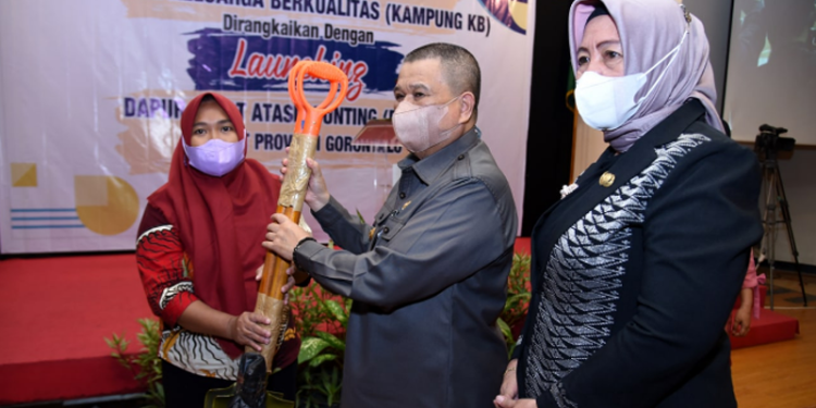 Wagub Gorontalo H. Idris Rahim (tengah) menyerahkan bantuan alat TTG kepada Kelompok UPPKA Beringin Kampung KB Tomulabutao pada penguatan kemitraan dan peluncuran program Dashat di Hotel Grand Q, Kota Gorontalo, Kamis (24/3/2022). (Foto: Haris)