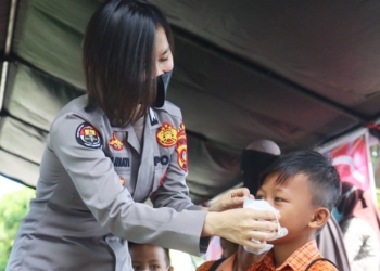 Briptu Nia Yaniati yang bertugas di Humas Polda Gorontalo melakukan sambang warga dilapangan apel Polda Gorontalo Saban hari, ia ikut diterjunkan dalam peliputan Vaksinasi massal. (Foto: Humas Polda Gorontalo)