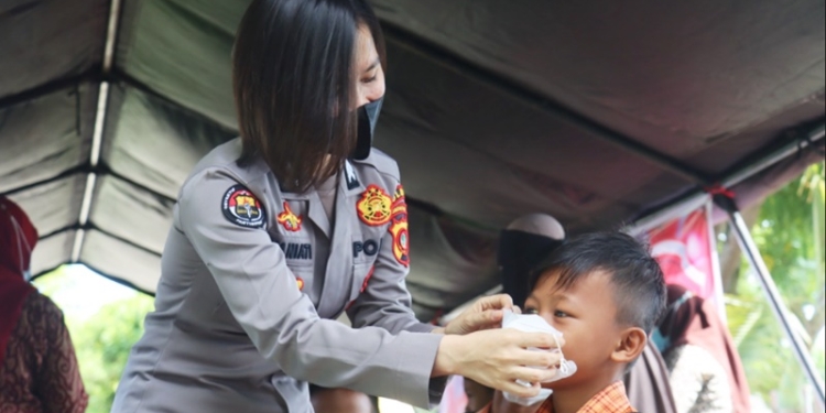 Briptu Nia Yaniati yang bertugas di Humas Polda Gorontalo melakukan sambang warga dilapangan apel Polda Gorontalo Saban hari, ia ikut diterjunkan dalam peliputan Vaksinasi massal. (Foto: Humas Polda Gorontalo)