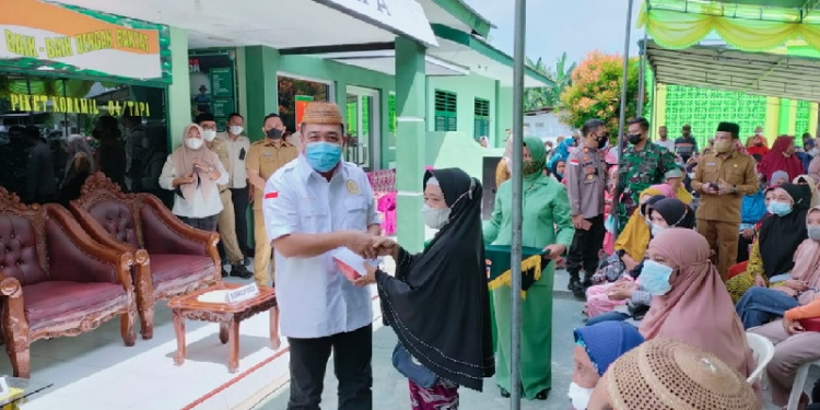 Ketua Dewan Perwakilan Rakyat Daerah (DPRD) Kabupaten Bone Bolango, Halid Tangahu menyalurkan Bantuan Tunai Pedagang Kaki Lima, Warung, dan Nelayan (BT-PKLWN) untuk masyarakat. (Foto: Istimewa)